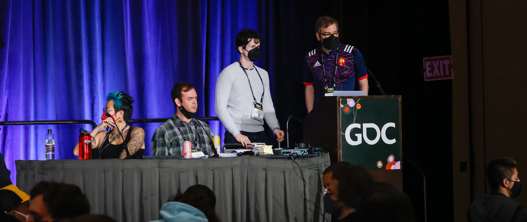 4 Panelists at GDC for our Climate Change workshop: Paula Escuadra, Chance Glasco, Trevin York, and Grant Shonkwiler, standing at the table and podium with some audience members discussing their projects below.